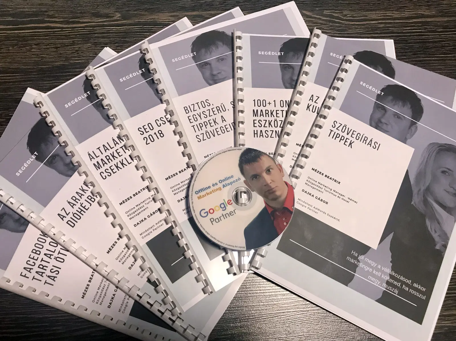 Több spirálozott képzési segédlet és Google Partner-jelzésű adathordozó egymás mellett